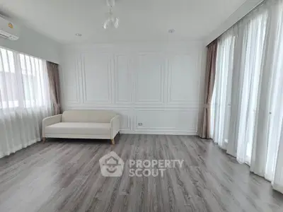 Spacious and elegant living room with large windows and modern flooring.