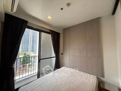 Modern bedroom with city view and balcony access in high-rise apartment