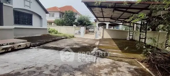 Spacious residential driveway with covered parking and gated entrance