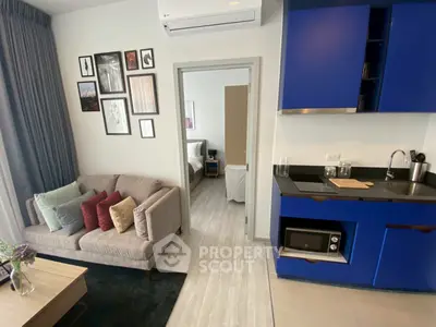 Modern apartment interior with blue kitchen and cozy living area