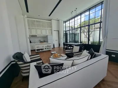 Luxurious open-plan living room with elegant decor and large windows offering abundant natural light.