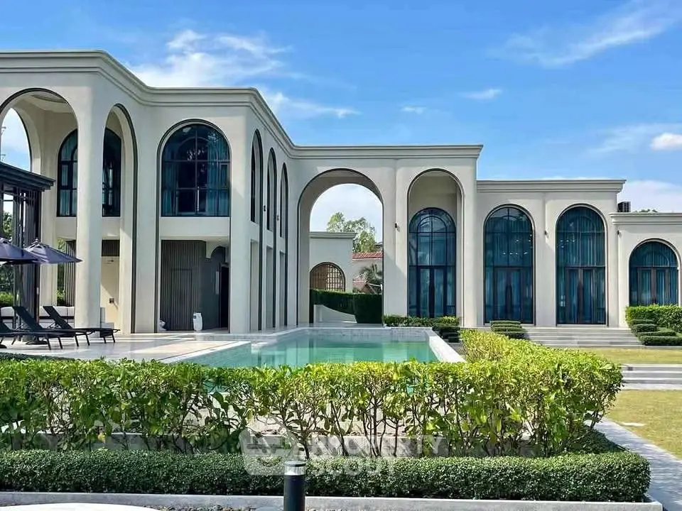Luxurious modern villa with elegant arches and private pool, surrounded by lush greenery.