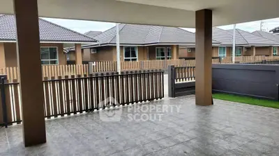 Spacious covered patio with tiled flooring and view of modern suburban homes.