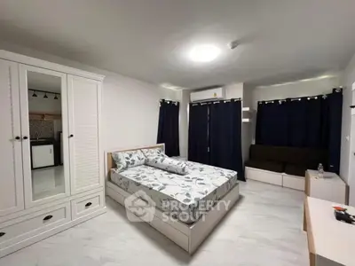Spacious bedroom with modern decor and ample storage in a stylish apartment.