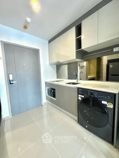 Modern kitchen with sleek cabinets and built-in washing machine