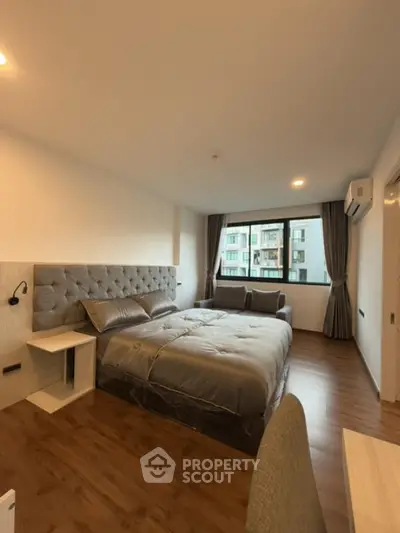 Spacious bedroom with modern decor and large window view