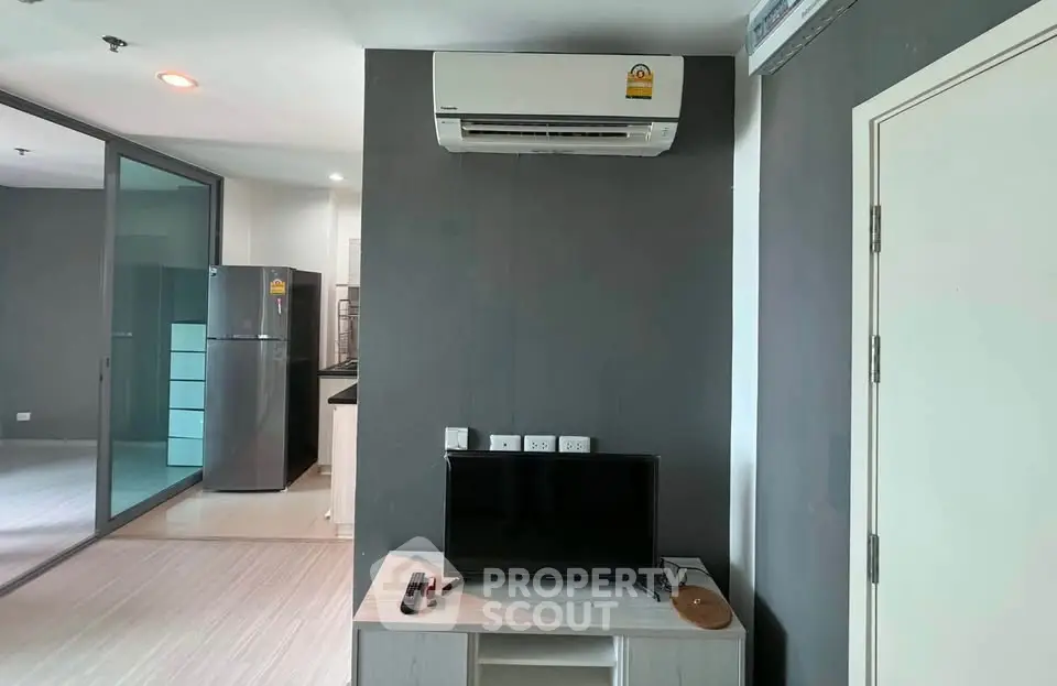 Modern apartment interior with air conditioning and sleek kitchen appliances.