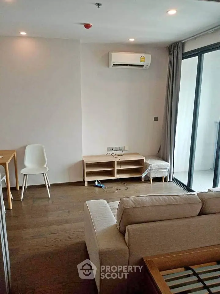 Modern living room with air conditioning and balcony access in a stylish apartment.