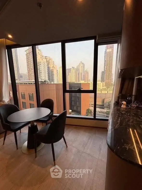 Modern dining area with stunning city view from large windows in high-rise apartment.