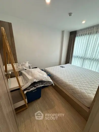 Cozy bedroom with natural light and modern decor, featuring a comfortable bed and stylish furnishings.