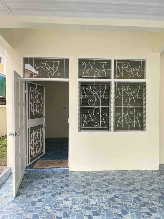 Charming home entrance with decorative ironwork and tiled patio
