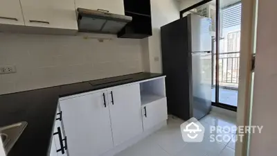 Modern kitchen with sleek cabinets and large fridge in a high-rise apartment