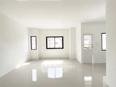 Spacious sunlit room with glossy tiled floors and large windows