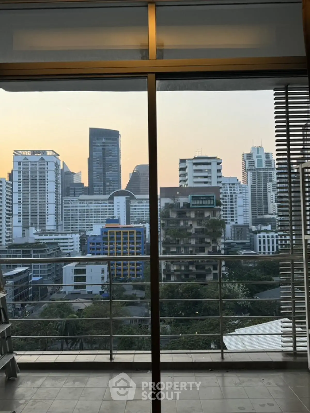 Stunning urban skyline view from modern apartment balcony at sunset