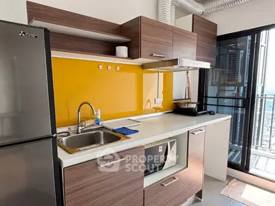 Modern kitchen with sleek cabinetry and vibrant yellow backsplash in high-rise apartment.