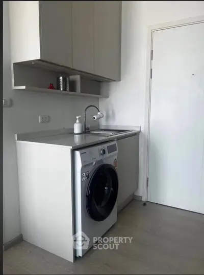 Modern laundry area with washing machine and storage cabinets