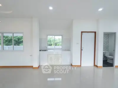 Spacious open-plan living area with large windows and modern finishes, perfect for natural light and comfort.