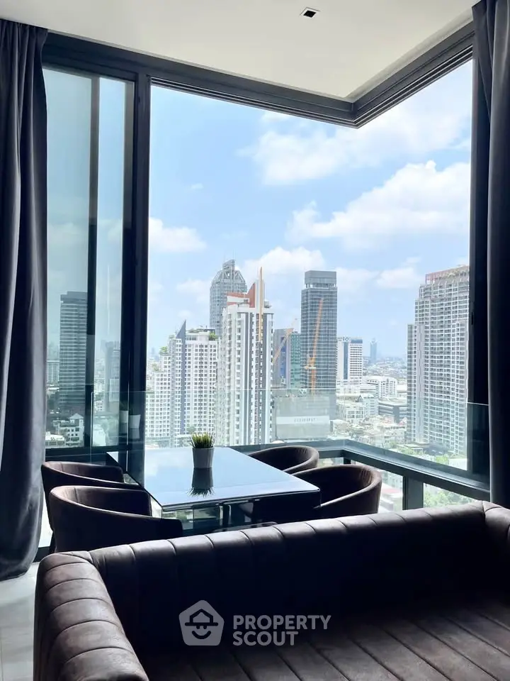 Luxurious living room with stunning city skyline view through floor-to-ceiling windows.