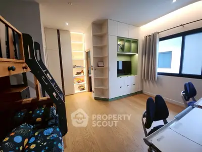 Modern children's room with bunk bed, study area, and built-in storage