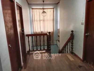 Charming vintage hallway with wooden floors and classic railing, perfect for a cozy home renovation project.