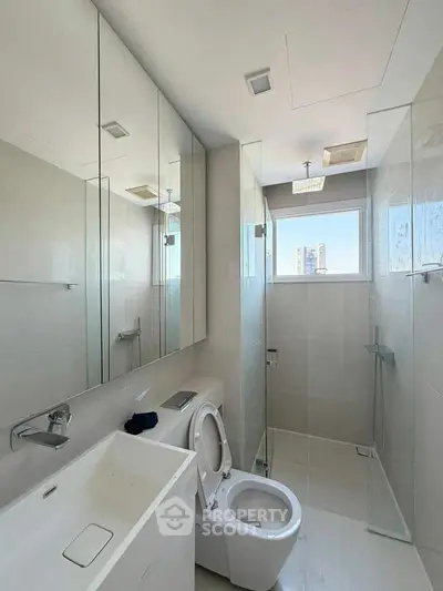 Modern bathroom with sleek fixtures and large mirrors in a high-rise apartment.
