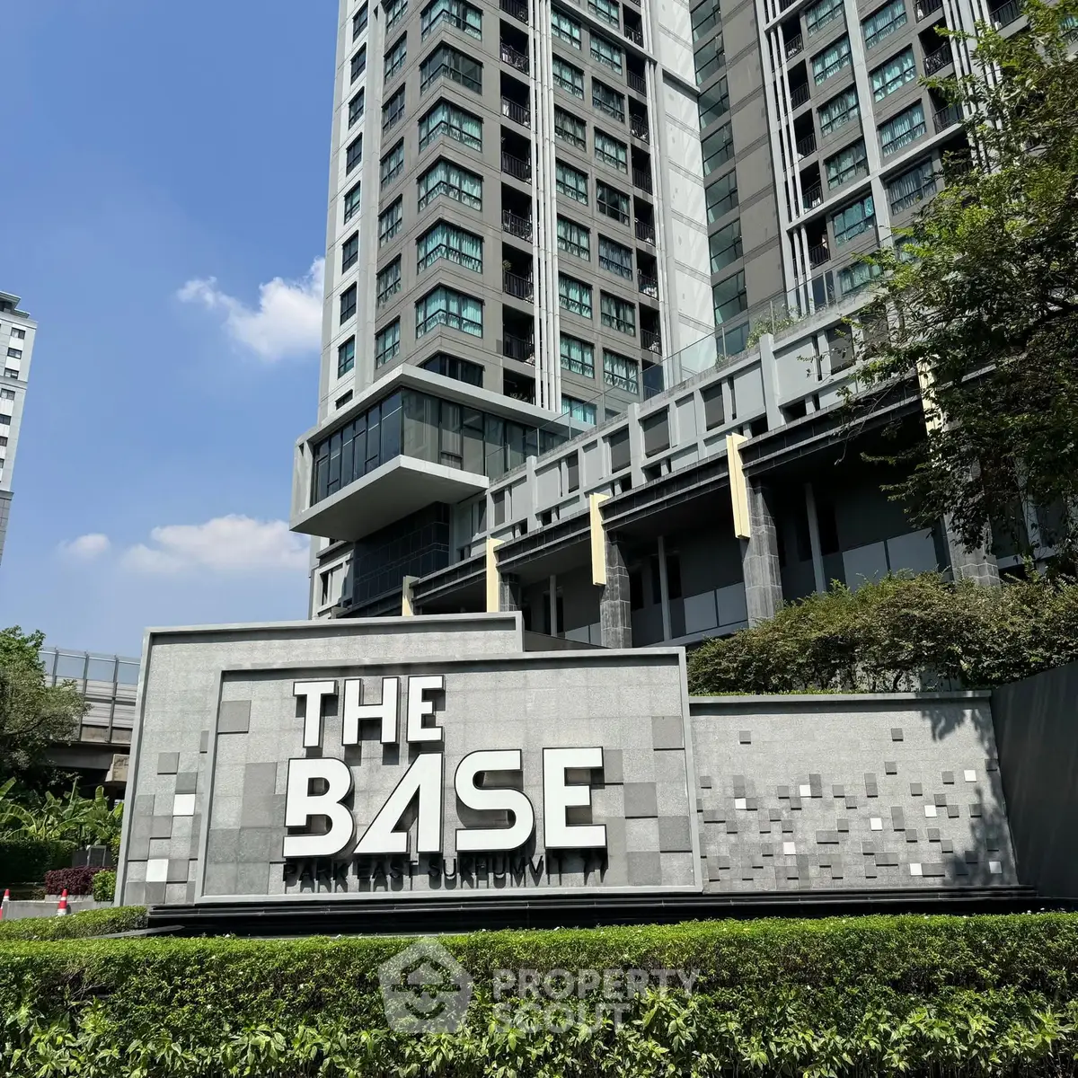 Modern high-rise condominium with sleek architectural design and lush greenery.