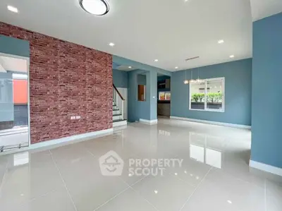 Spacious modern living room with brick accent wall and large windows