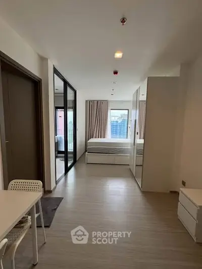 Modern studio apartment with sleek design and large windows offering city views.