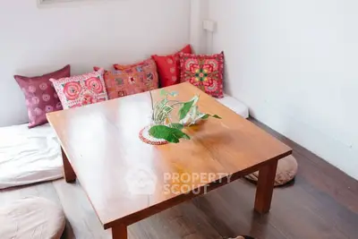 Cozy living room with wooden table and colorful cushions, perfect for relaxation.