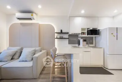 Modern open-layout kitchen and living area with sleek design and neutral tones.