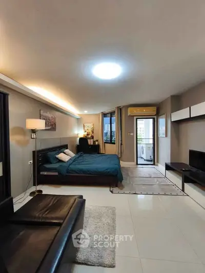 Spacious modern studio apartment with sleek design and city view balcony.