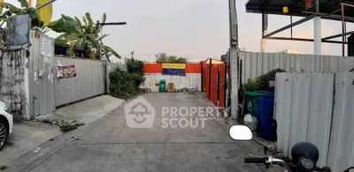 Secure gated entrance with concrete driveway and surrounding metal fencing, ideal for privacy and security.