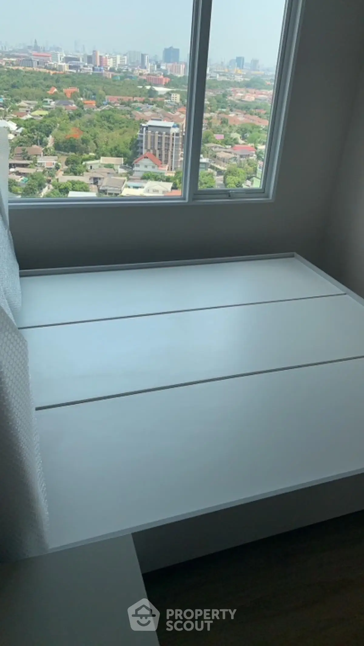 Modern bedroom with panoramic city view from high-rise window