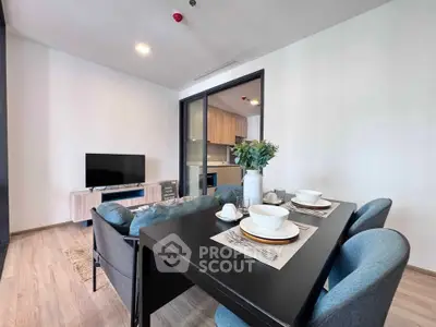 Modern living room with dining area and sleek kitchen in open layout apartment.