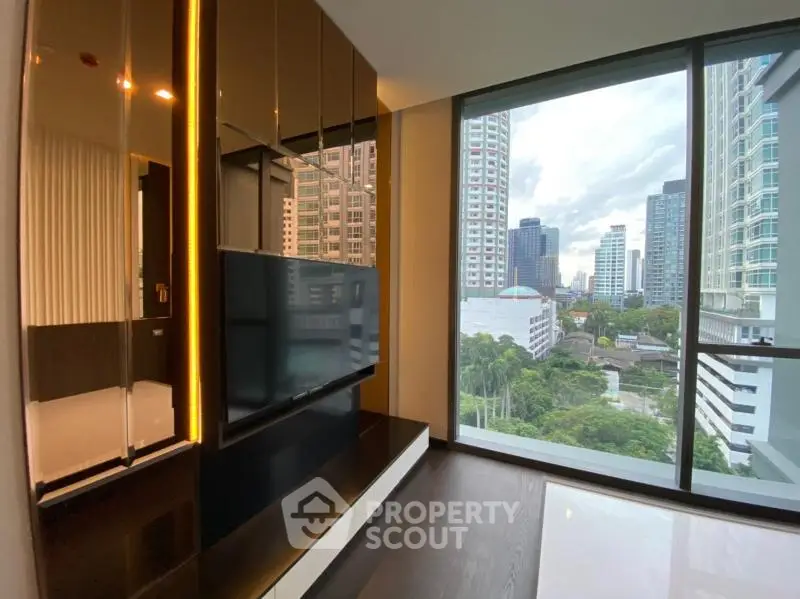 Modern living room with large windows offering stunning cityscape views in a high-rise apartment.