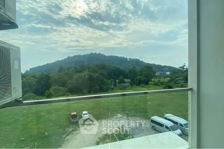 Stunning balcony view of lush green landscape and distant hills.