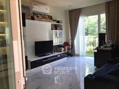 Spacious living room with modern decor and large window overlooking greenery.