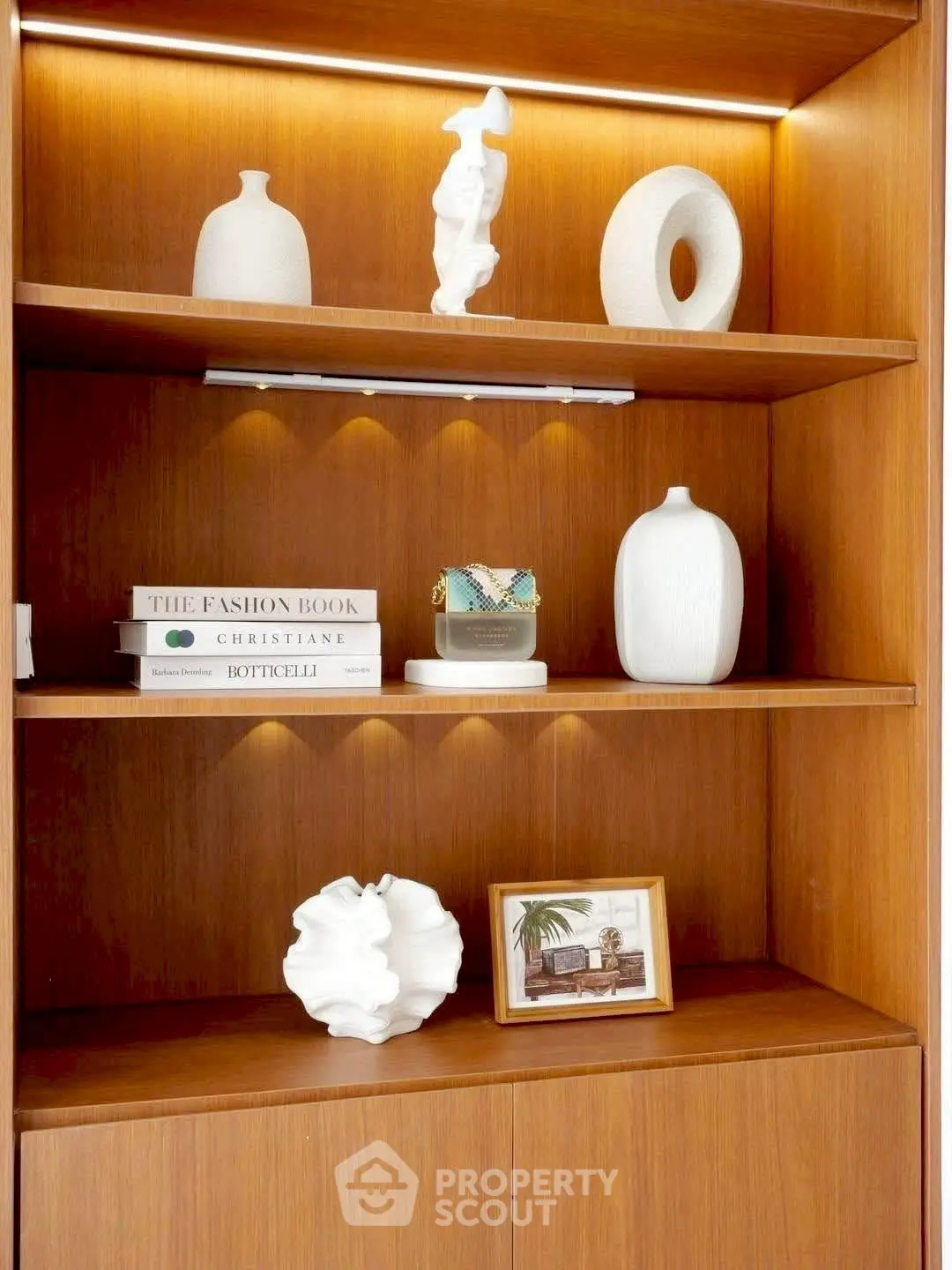 Elegant wooden shelving with stylish decor and books in a modern living room setting.
