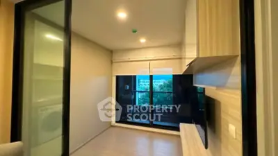 Modern living room with sliding glass doors leading to a balcony, featuring sleek built-in shelving.