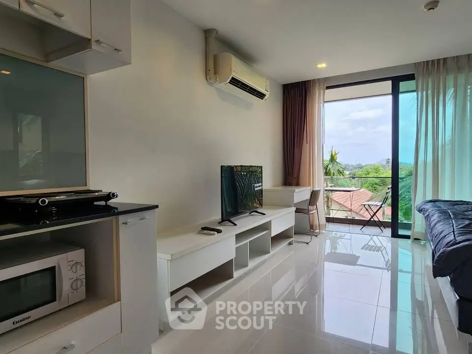 Modern living room with balcony view, sleek furniture, and natural light in a stylish apartment.
