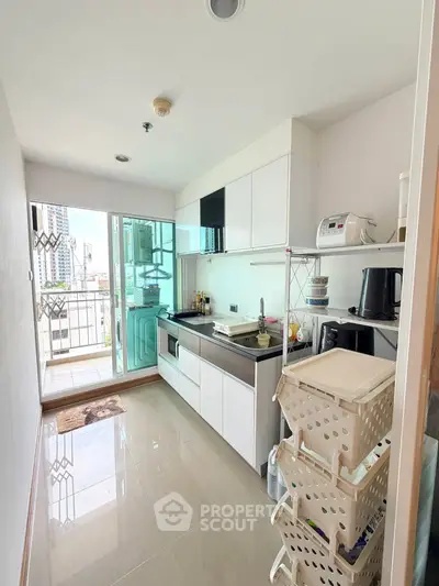Modern kitchen with sleek cabinetry and balcony view in urban apartment