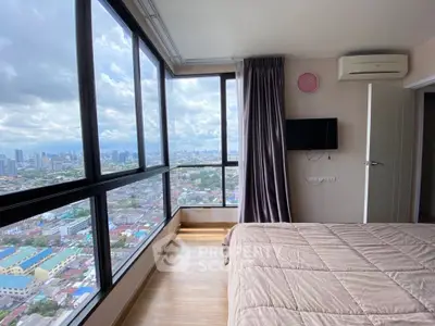 Stunning bedroom with panoramic city view and modern amenities in high-rise apartment.