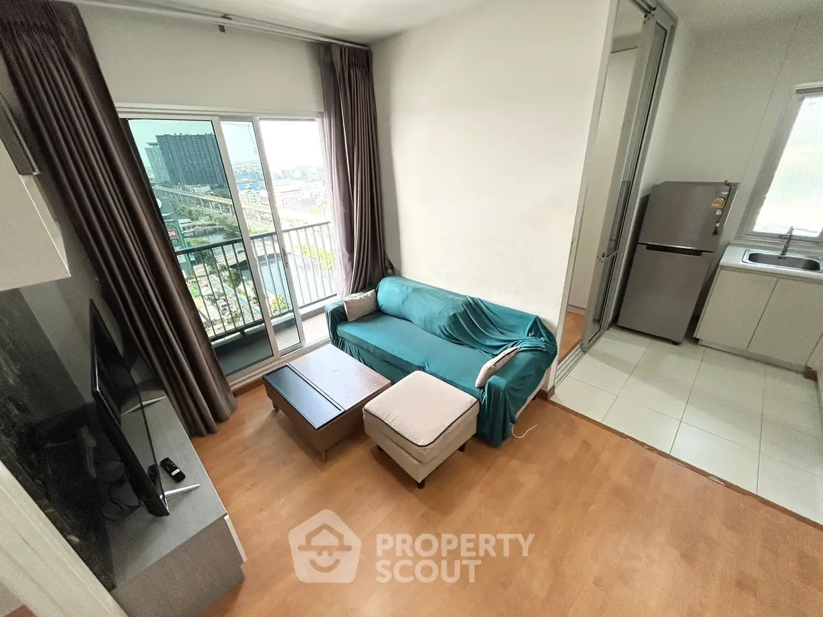 Modern living room with balcony view and adjacent kitchen in a stylish apartment.