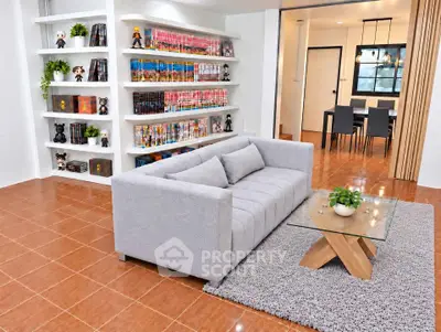Spacious living room with modern gray sofa and stylish bookshelf