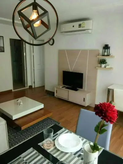 Modern living room with stylish lighting and air conditioning, featuring a cozy dining area.