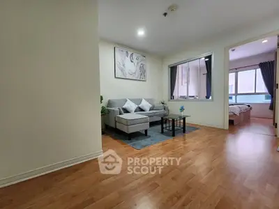 Spacious living room with modern decor and wooden flooring in a cozy apartment.