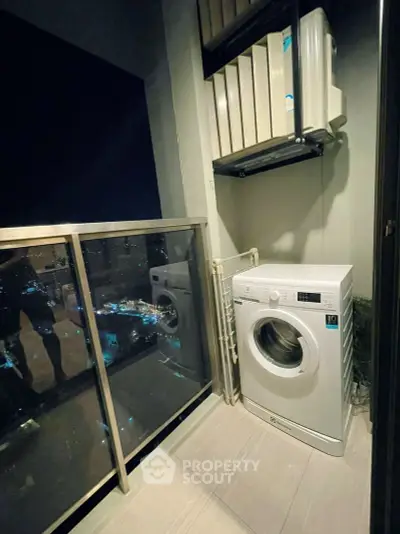 Modern balcony with washing machine and city view at night