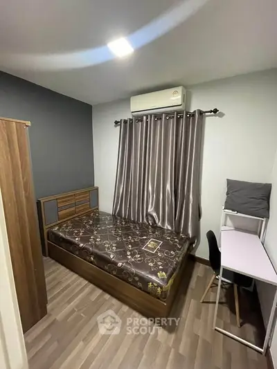 Cozy bedroom with modern furnishings and air conditioning, perfect for comfortable living.