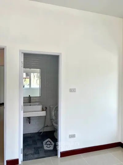 Compact bathroom with modern fixtures and white tiled walls in a minimalist home.