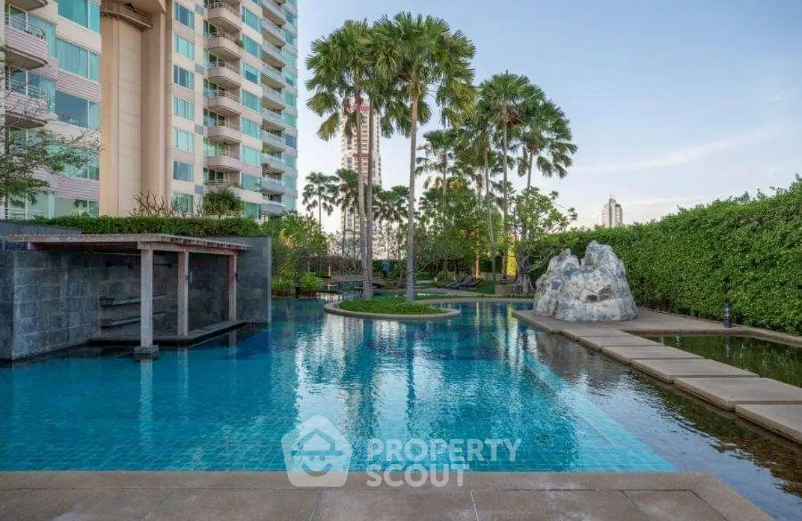 Luxurious condominium pool with lush greenery and modern design.
